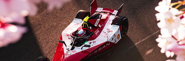 Carro da Equipe Nissan de Fórmula E na pista entre flores de cerejeiras